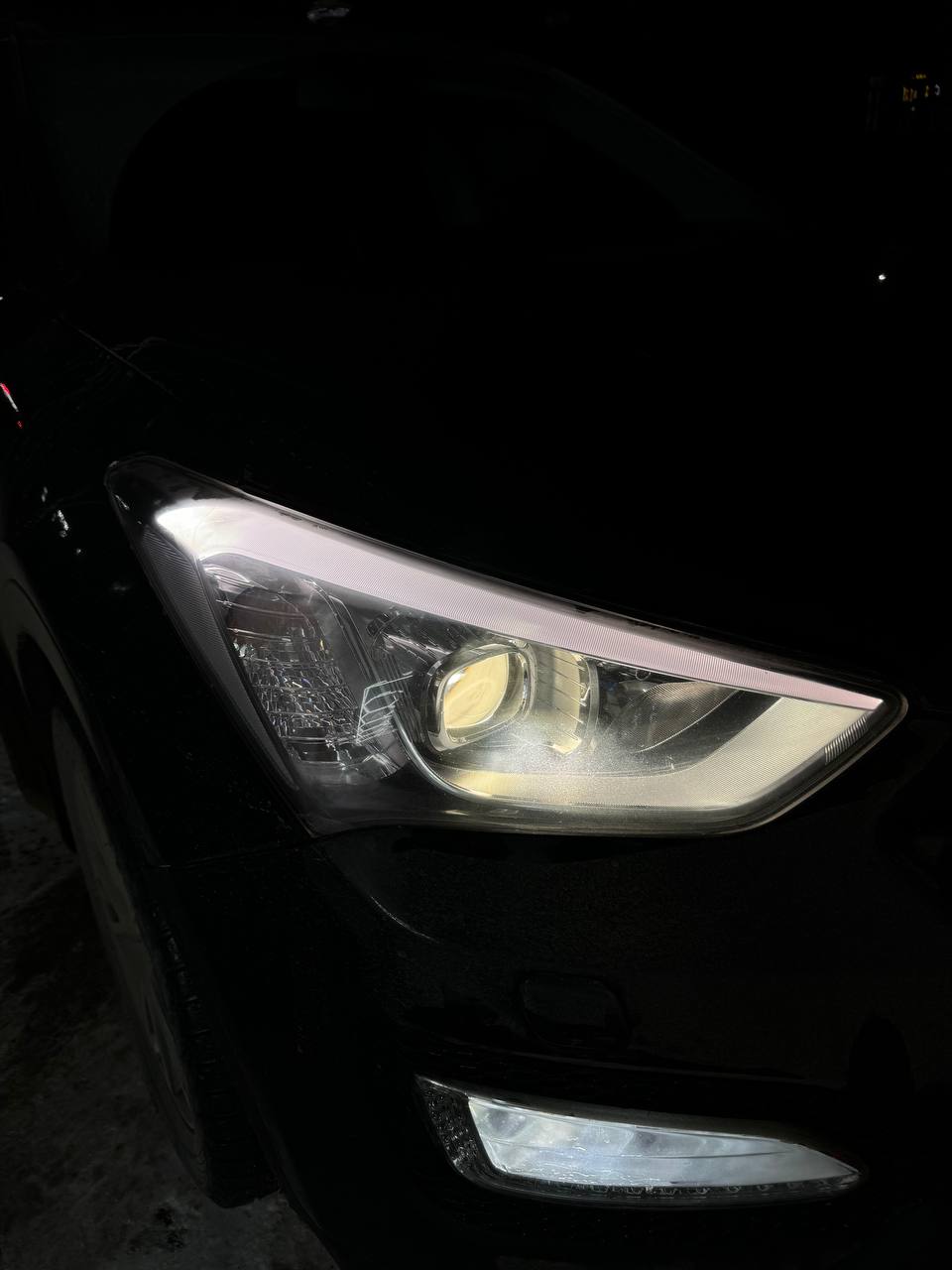 Hyundai Santa Fe 2012 с ксеноновой фарой, где круглый модуль визуально попадает в квадратную геометрию секции